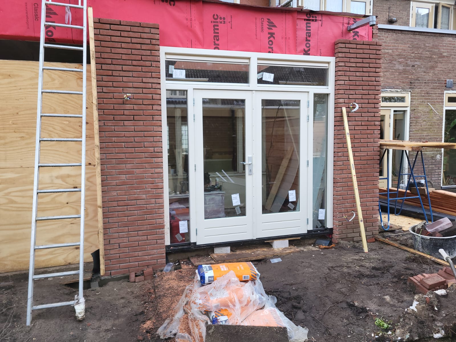 Nieuwe witte houten kozijnen met openslaande deuren geplaatst in een woning